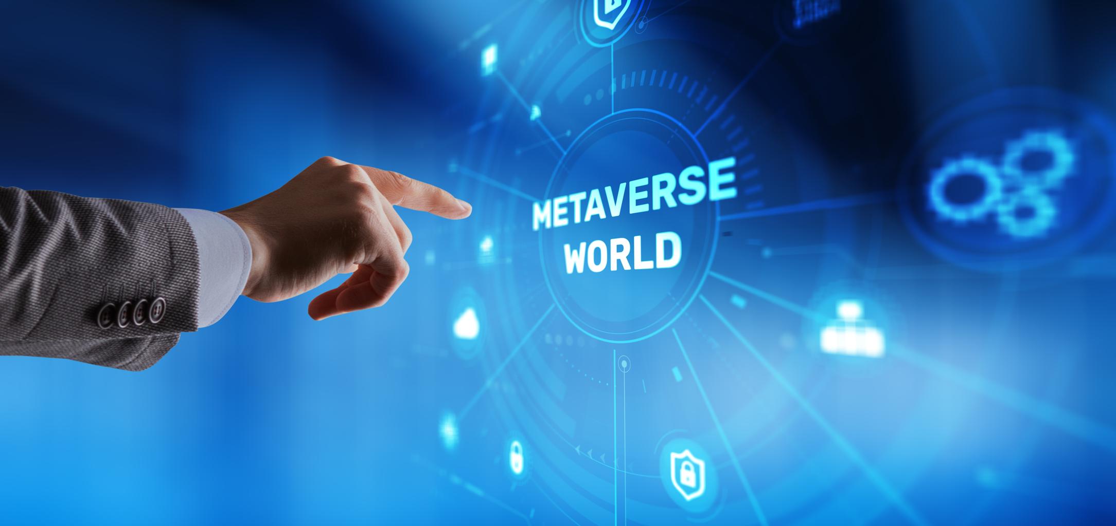 Imagem com predominância de tons azuis e efeitos luminosos digitais, representando um ambiente tecnológico futurista. No centro, destaca-se o texto “Metaverse World”, rodeado por elementos gráficos circulares e ícones digitais. À esquerda, uma mão humana interage com a interface, simbolizando a ligação entre o utilizador e os ambientes digitais imersivos.